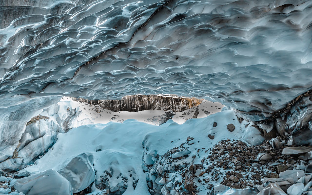 Stunning view from inside a glacial ice cave in Yunnan, China, showcasing intricate ice formations.